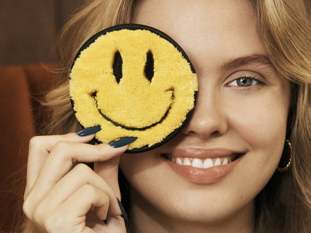 holding a smiling emoji cleansing cloth
