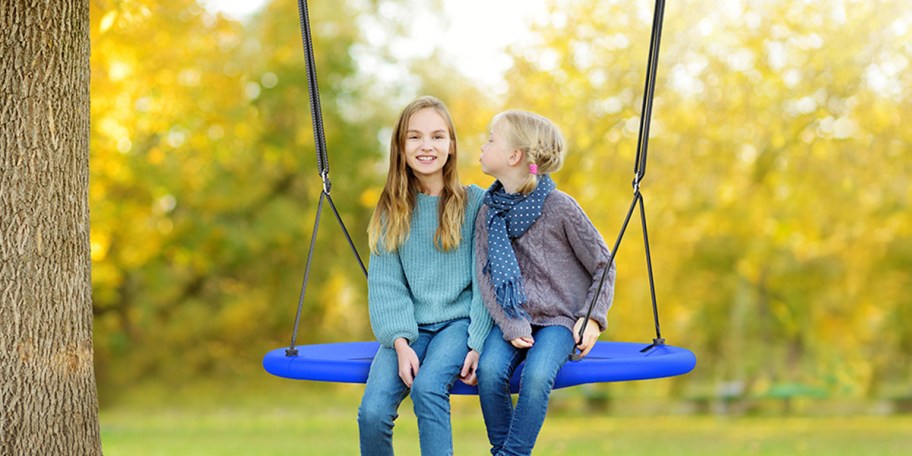 girls swinging on blue tree swing