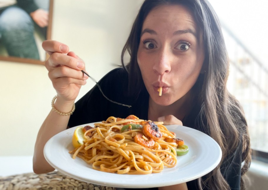woman eating plate of pasta