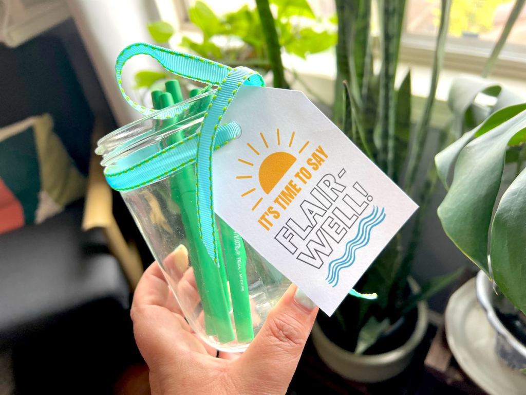 hand holding a clear jar with flair well gift tag
