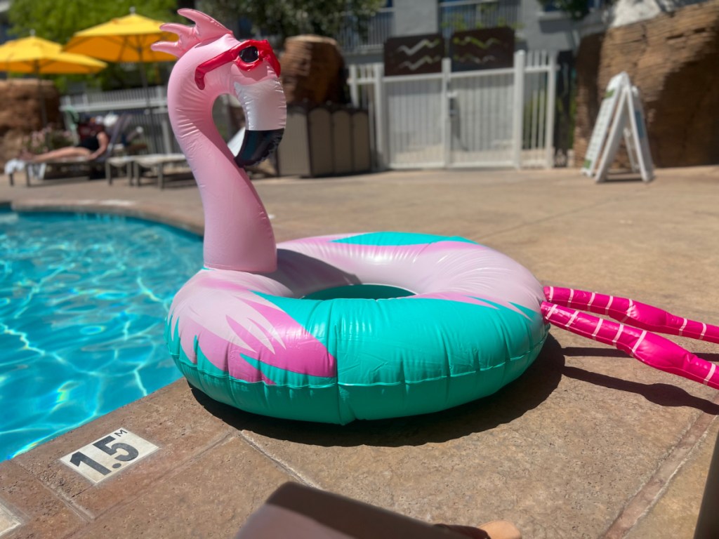 huge flamingo target pool float sitting on the ground near a pool