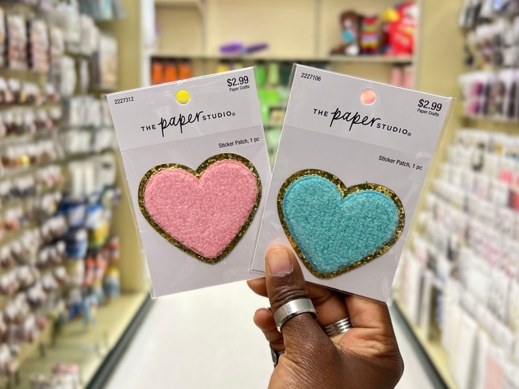 hand holding two hearts iron on patches in hobby lobby