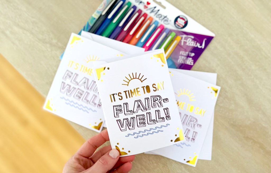 hand holding a teacher appreciation card printable over table with flair pens