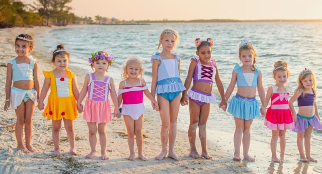 nine girls on beach in princess swimwear