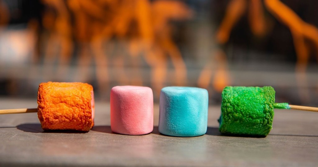colorful marshmallows on sticks near a fire