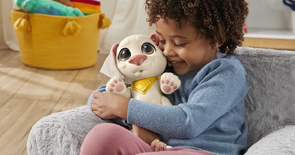 kid hugging Fisher-Price Dc League of Super-Pets Doll Toy on a couch