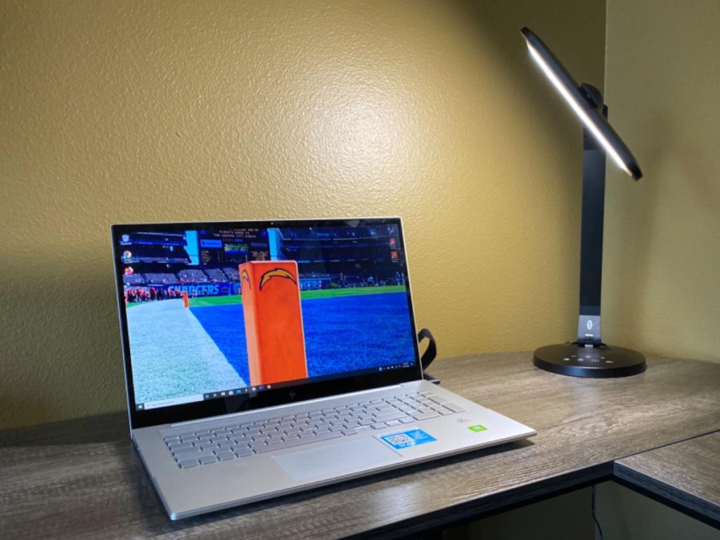 laptop on desk with lamp shining to laptop