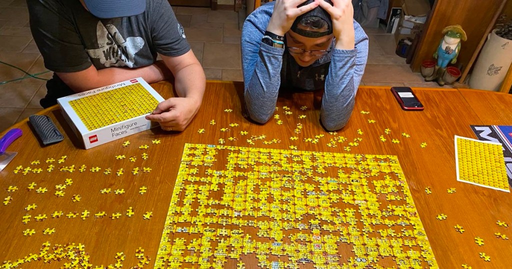 two men building minifigure puzzle