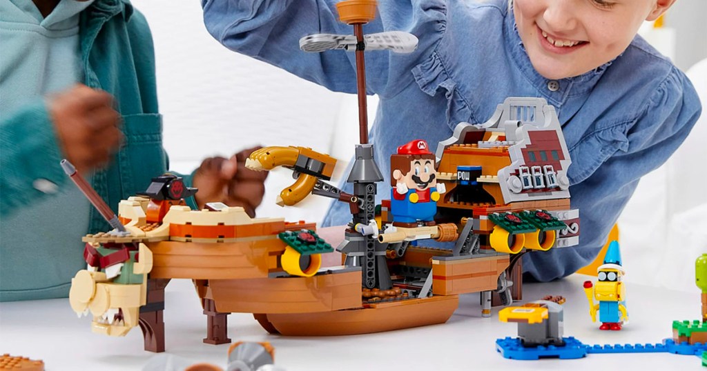 two kids playing with super mario bowsers airship lego set