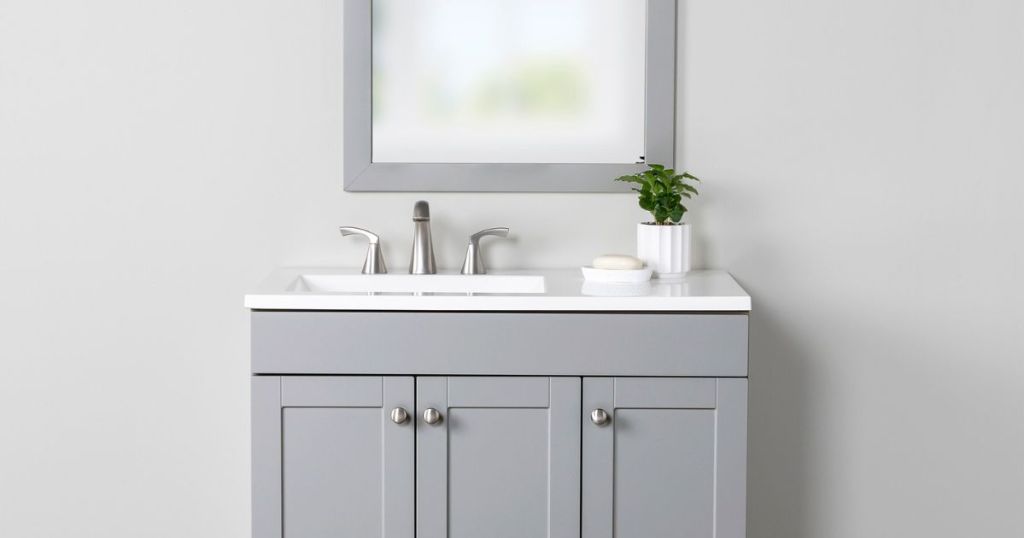 gray vanity with white top and matching mirror in bathroom