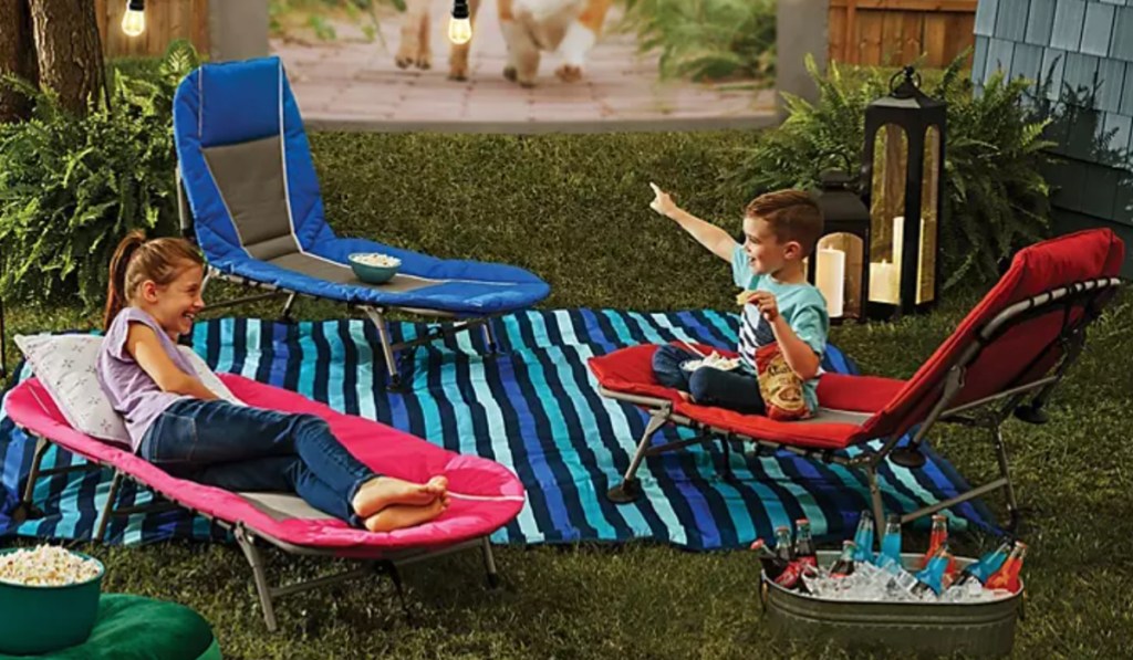 kids sitting on lounge chair cots outside