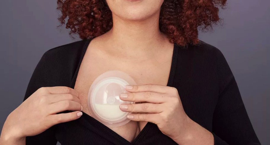 woman holding milk catcher on breast