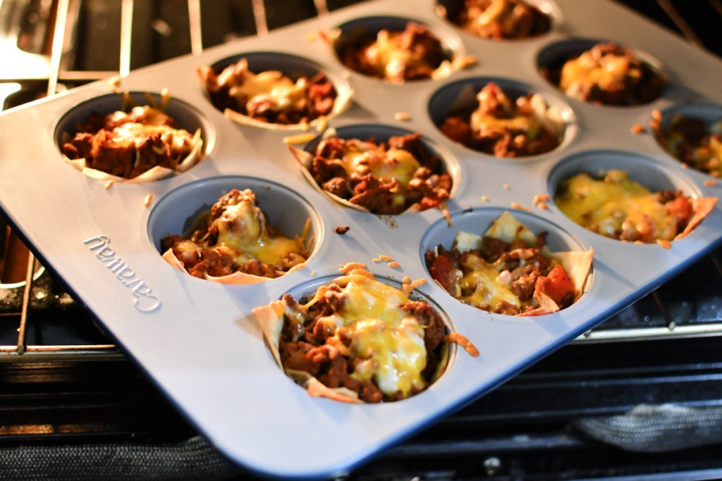 muffin pan in the oven baking with taco cups