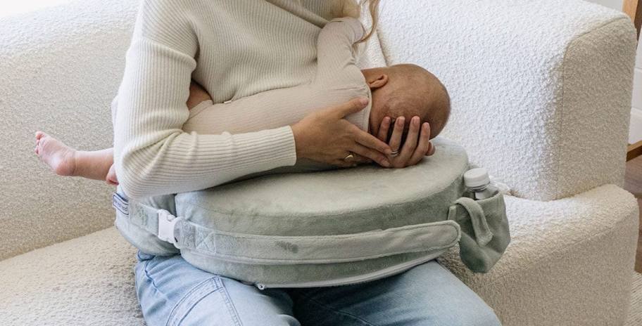 mother nursing baby on couch with my breast friend pillow