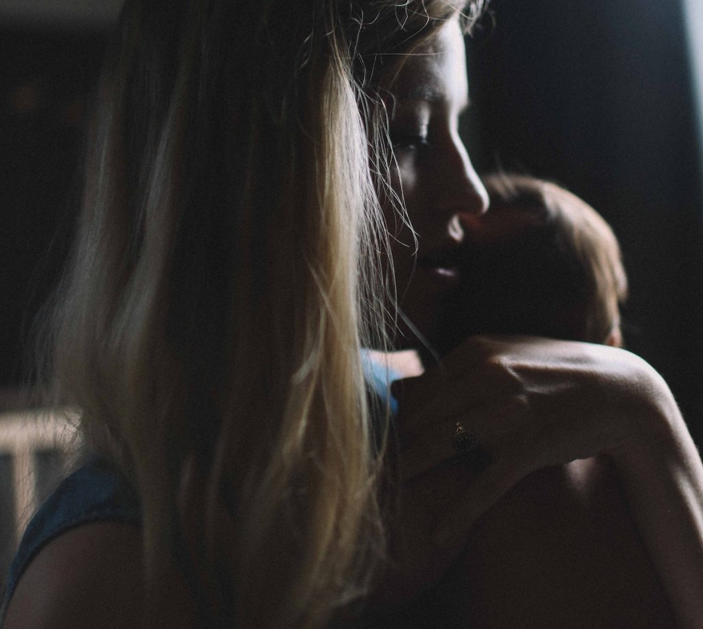 woman holding newborn baby in dark