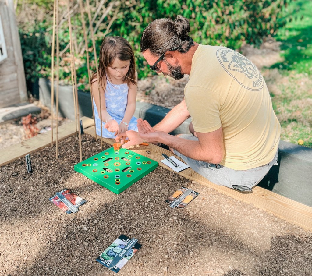 girl and man planting seeds in garden