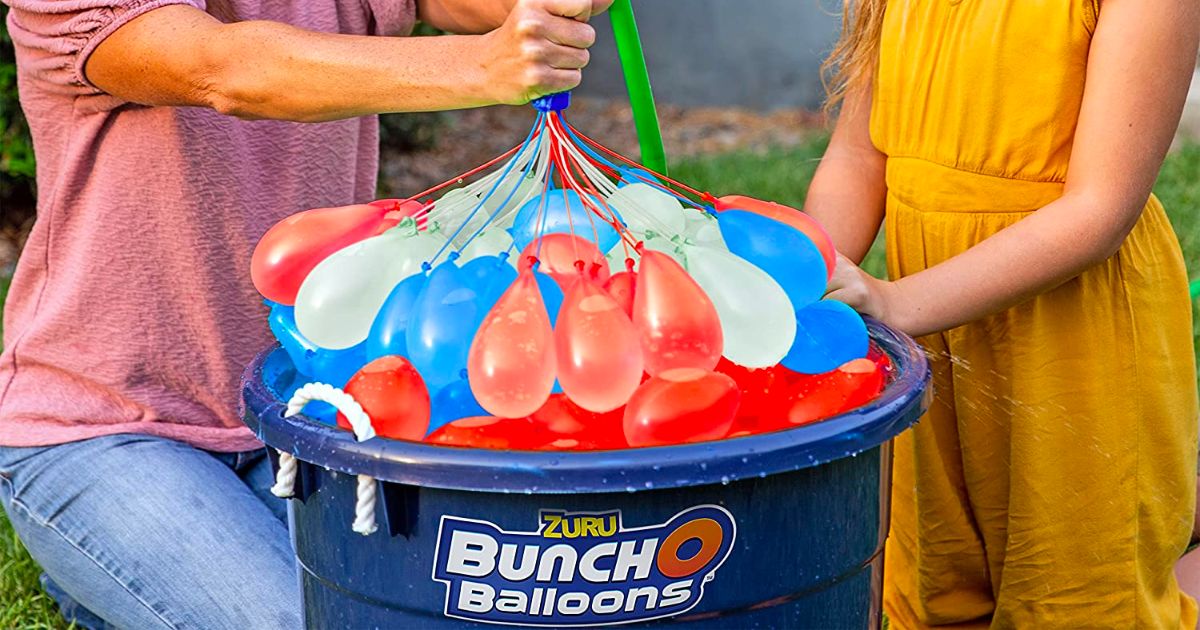 mom & daughter filling red white and blue bunch o balloons water balloons and placing in big plastic bucket