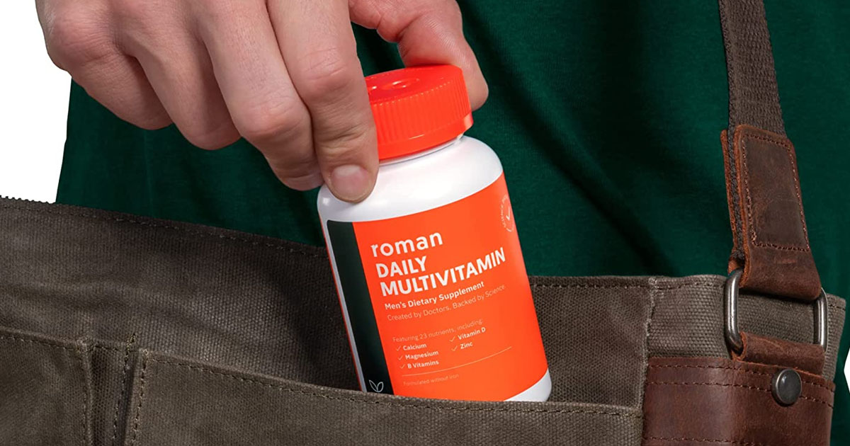 hand putting roman multivitamins in bag