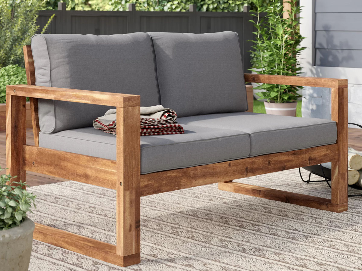 wooden loveseat with gray cushions on porch