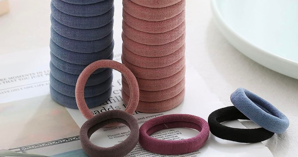 two stacks of blue and brown hair ties with multicolor hair ties laying on table