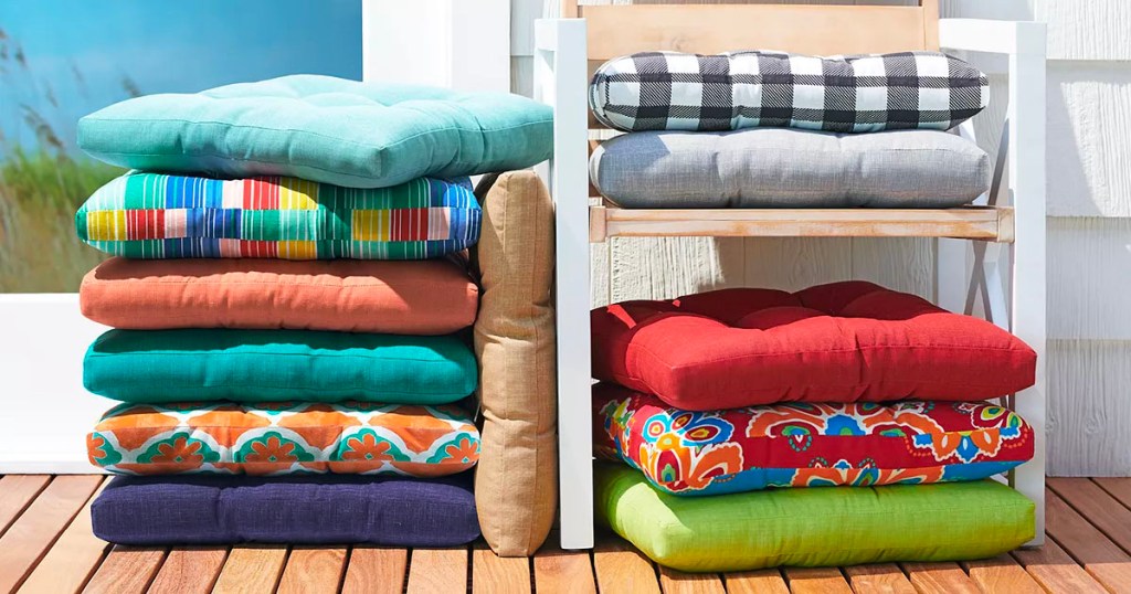 multicolored outdoor chair cusions stacked on deck