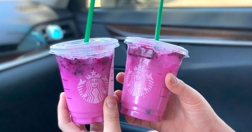 hand holding 2 pink Starbucks drinks