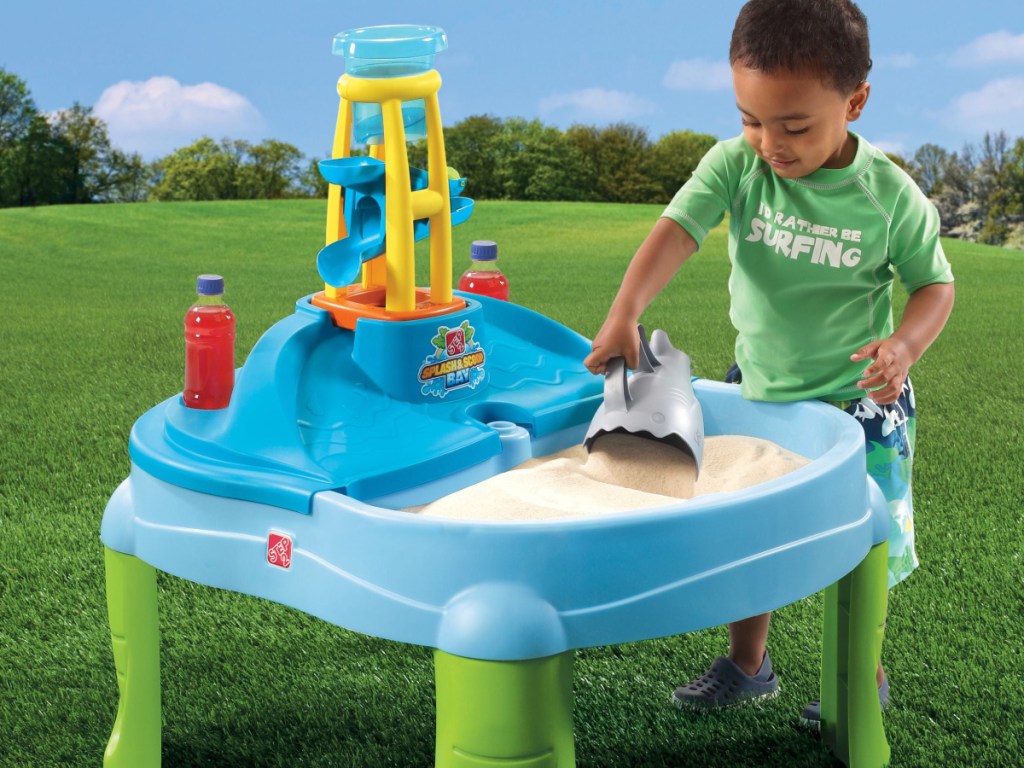 little boy playing with a step2 Splash 'N Scoop Bay sand and water table