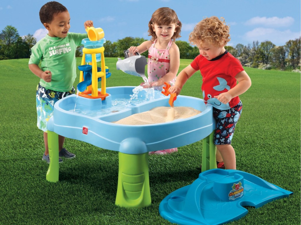 kids playing with a step2 Splash 'N Scoop Bay sand and water table