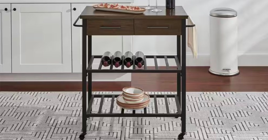 black and brown kitchen cart in kitchen with wine, cups nad plates sitting on it