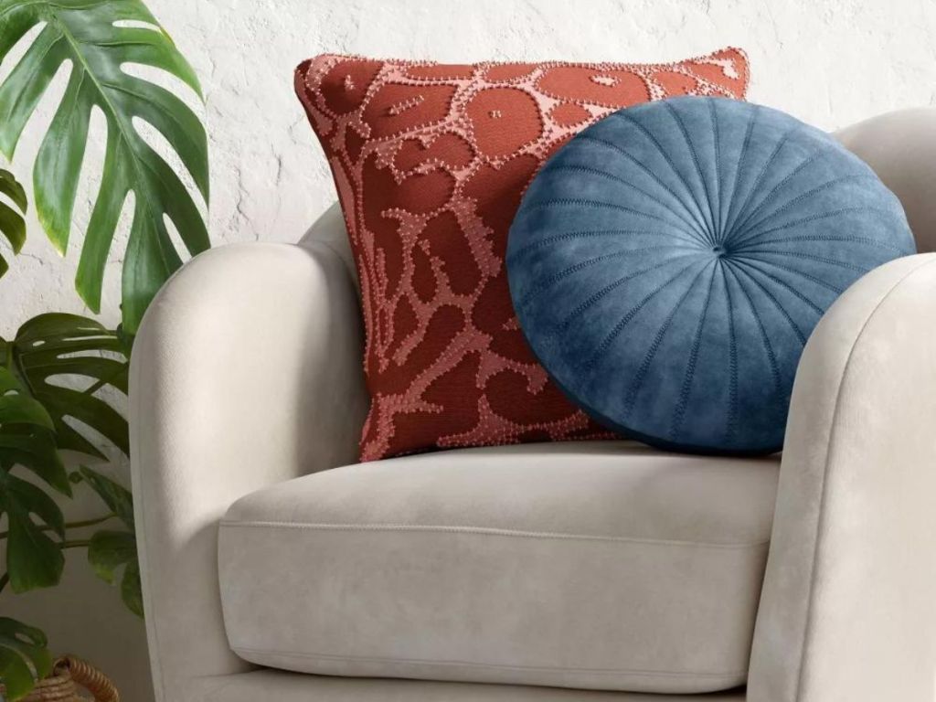 red throw pillow and blue round throw pillow on gray chair