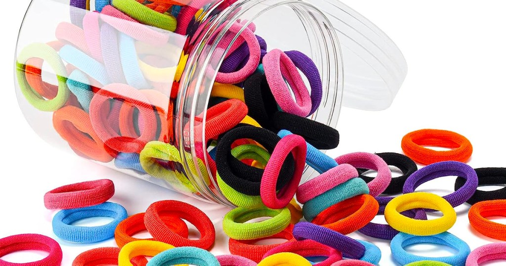 open jar full of multicolor hair ties spilling onto table