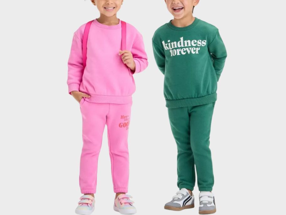 two kids wearing sweatshirts and joggers stock images