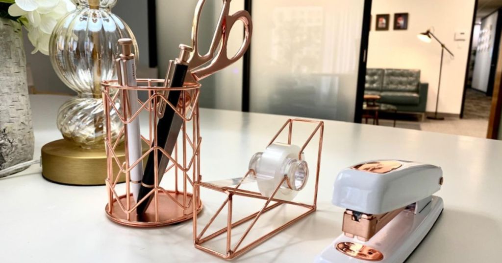rose gold office supplies on white desk in office
