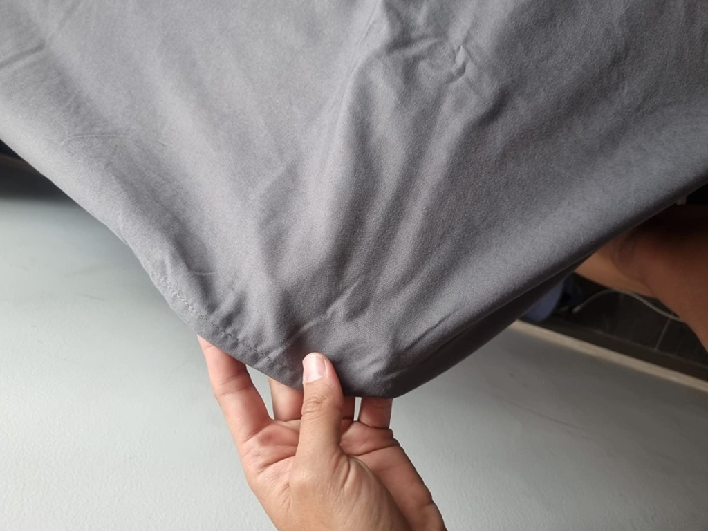 holding a gray fitted sheet