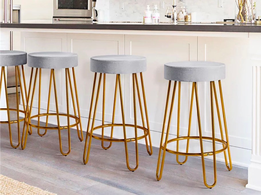 three gold and gray barstools lined up in kitchen