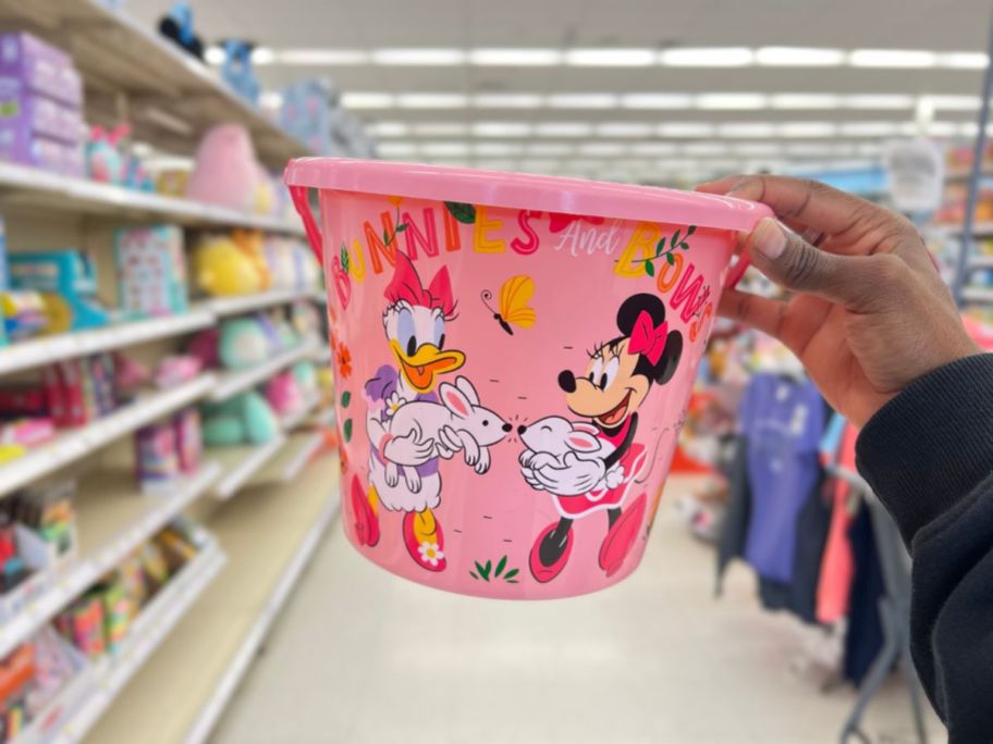 hand holding a pink Disney Minnie & Daisy Plastic Easter Bucket 