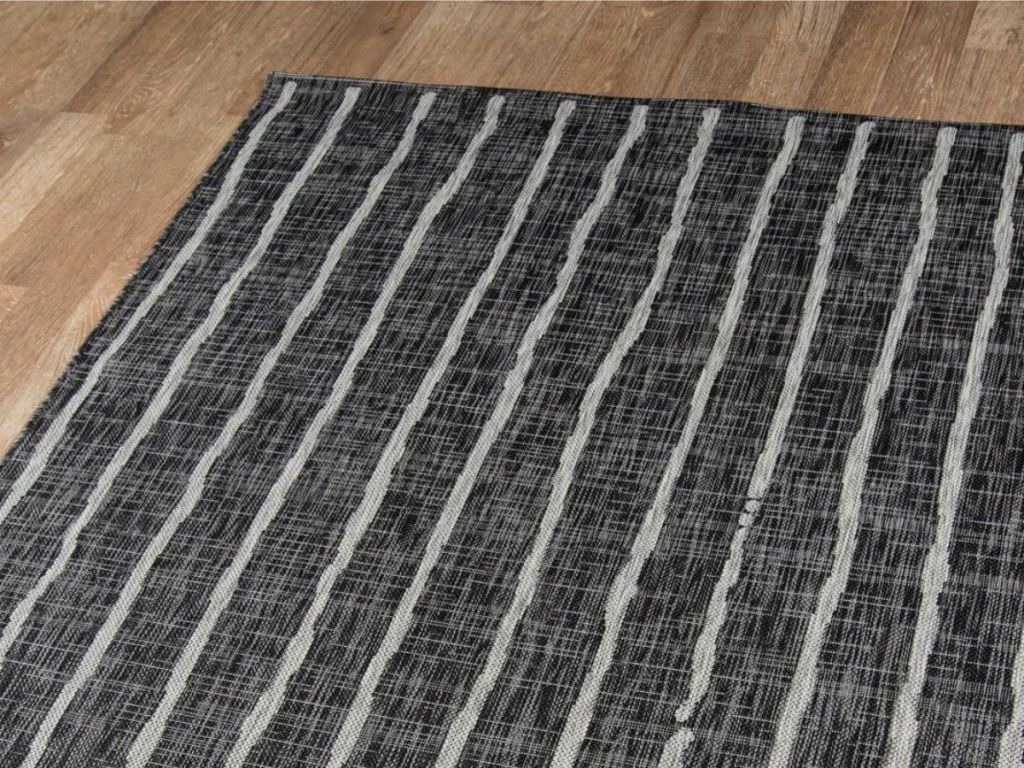 charcoal and white striped area rug on wood floor