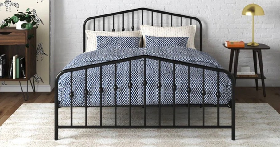 metal black bed with blue comforter set and white pillows 