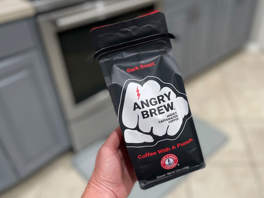 woman holding Five Lakes Coffee Angry Brew Dark Roast Grounds in her kitchen