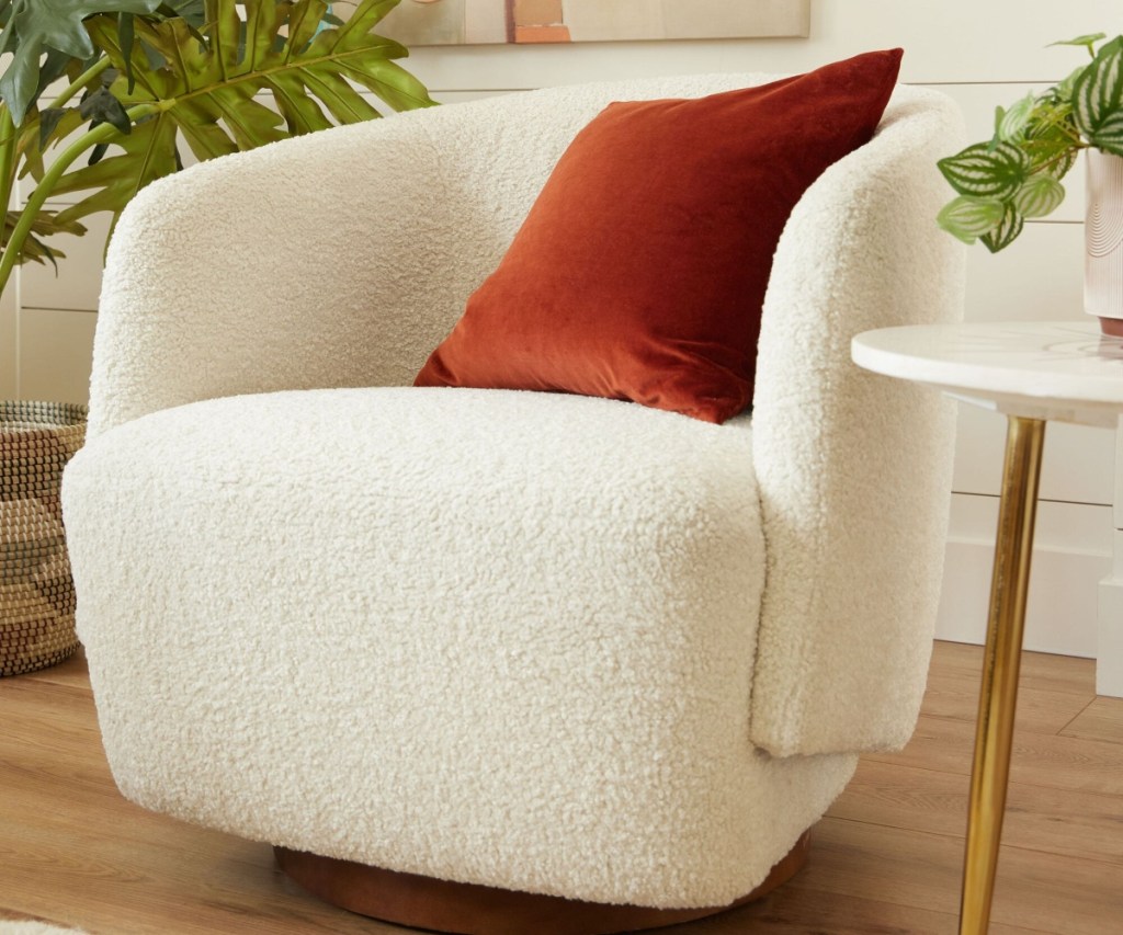 ivory chair with rust-colored throw pillow