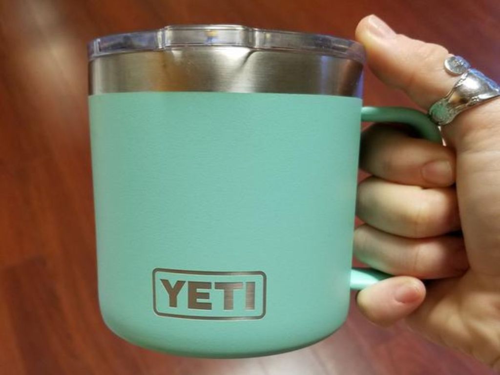 hand holding green YETI tumbler