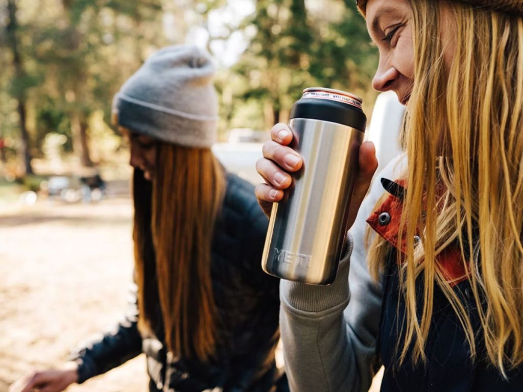 person drinking from stainless steel YETI can cooler