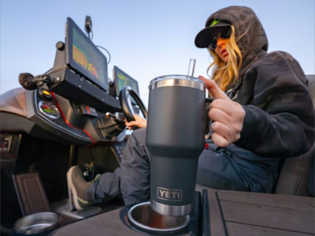 woan driving outdoor recreational vehicle with Yeti in cupholder