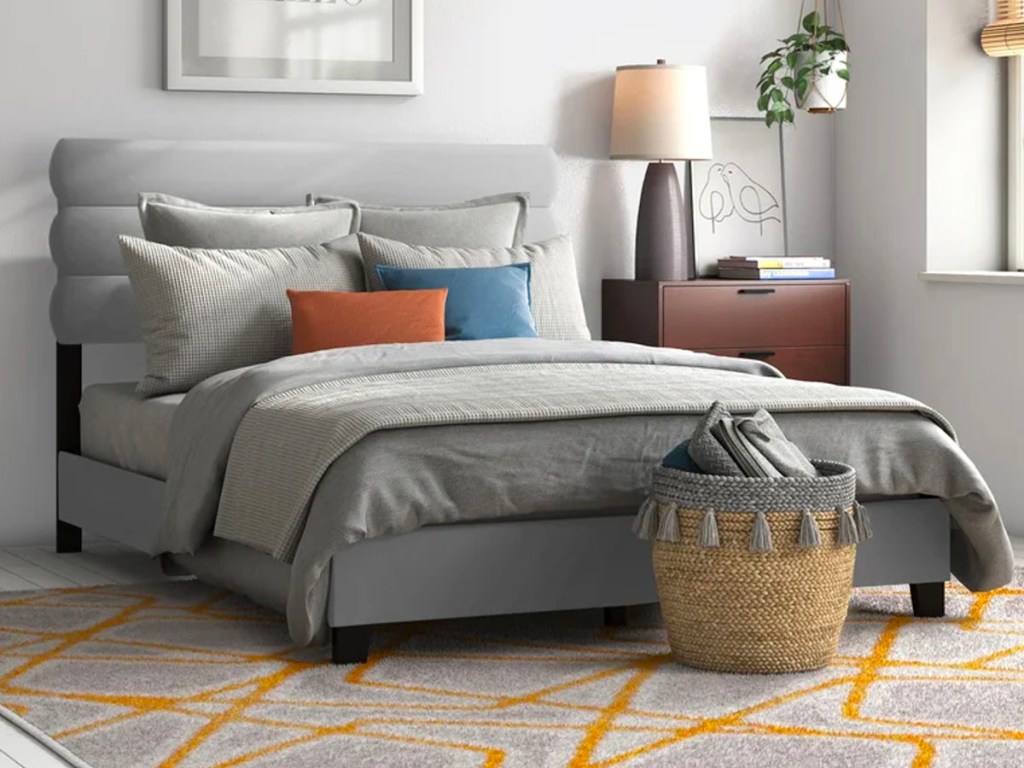 gray bedframe with gray comforter set in bedroom