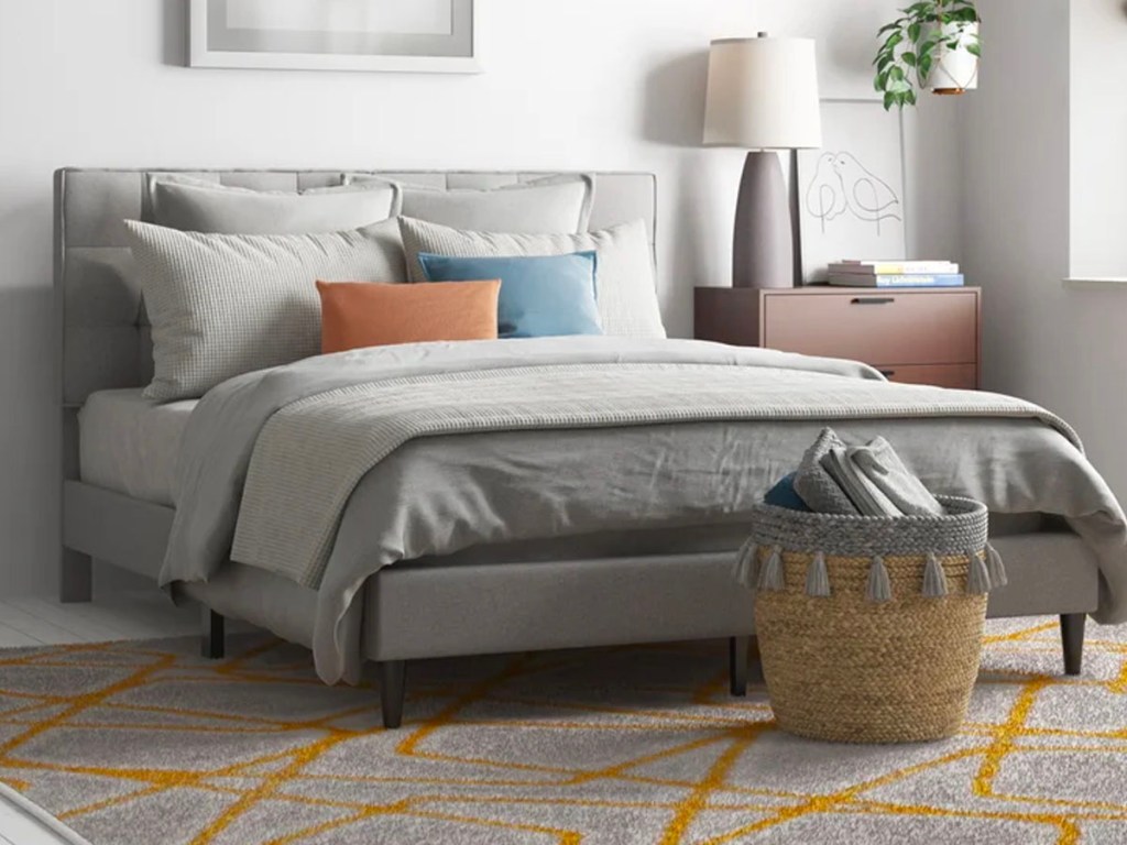 gray bedframe with gray comforter set in bedroom