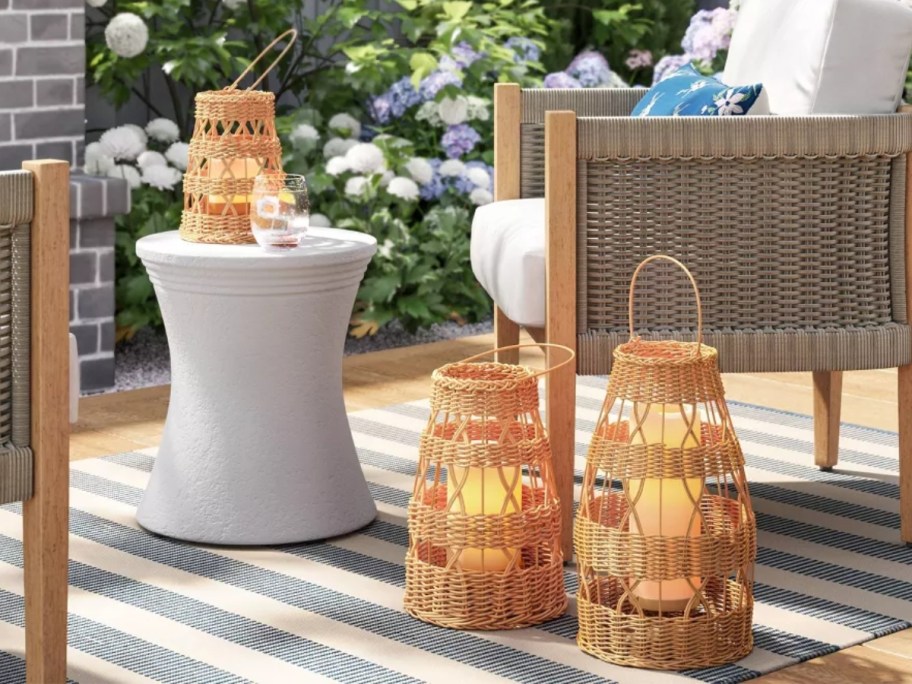 wicker/rattan style outdoor lanterns in 3 sizes on a back patio