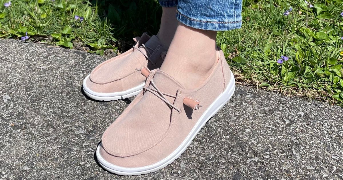 Person wearing a pink pair of canvas shoes