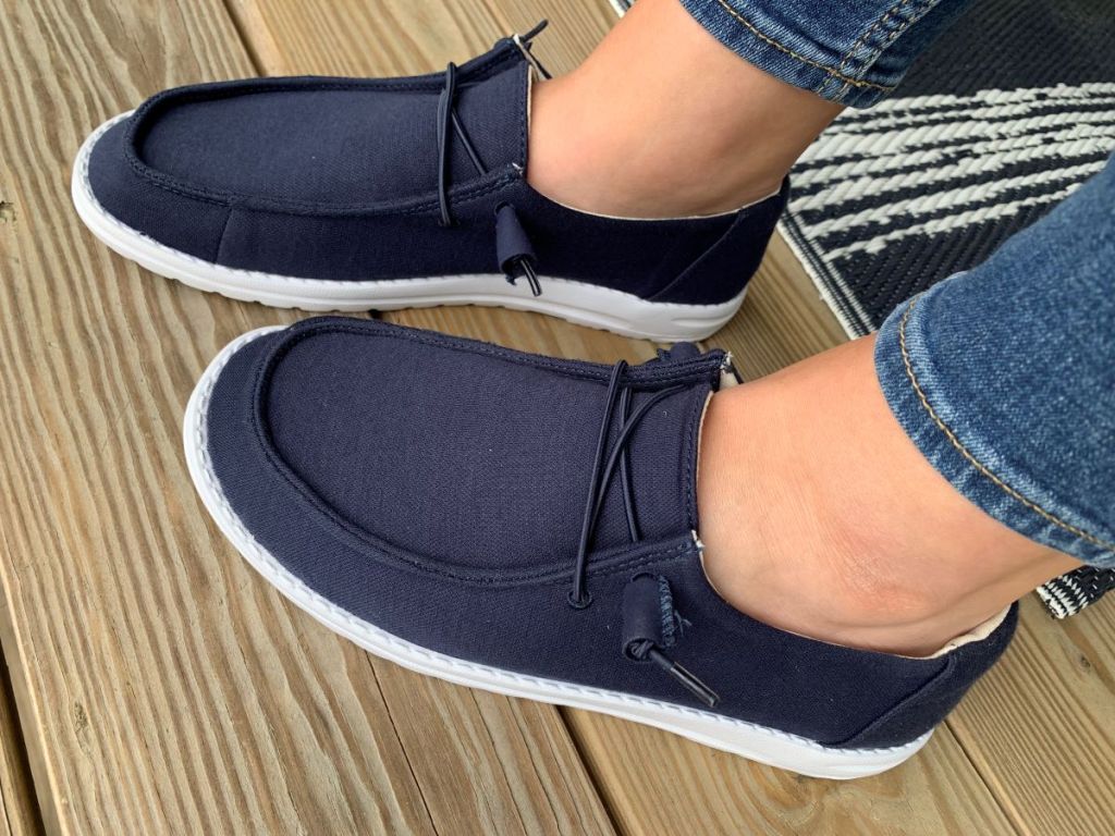Person wearing a pair of navy canvas shoes