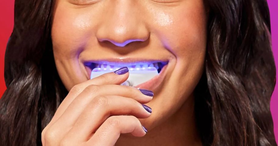 woman placing an LED teeth whitening tray in her mouth