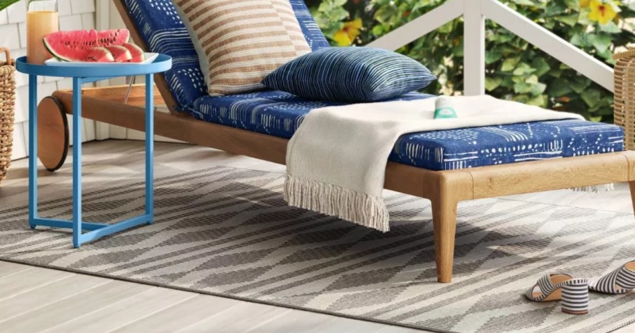 black and off white geometric print outdoor rug under a chaise lounge